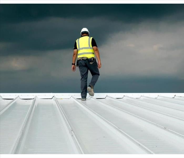 Construction engineer wearing safety uniform inspection metal roofing work for roof industrial 